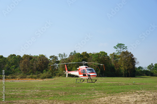 Helicopter parked at the helipad near forest
