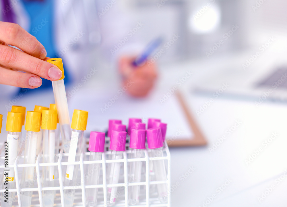 Woman researcher is surrounded by medical vials and flasks Woman researcher is surrounded by medical vials and flasks