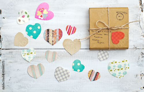 A gift on wooden background with hearts photo