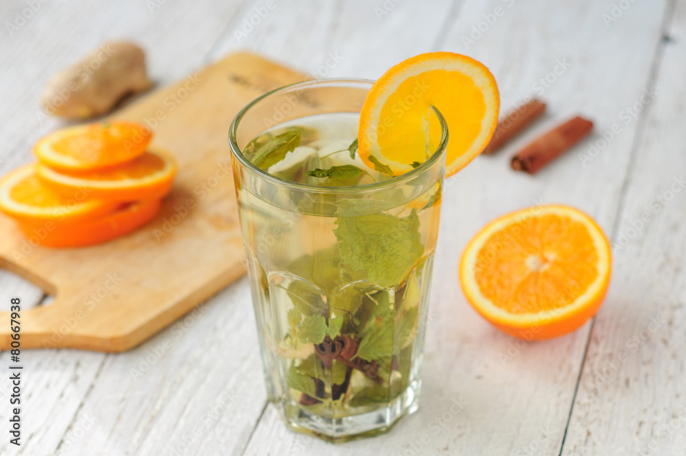 Fototapeta premium Herbal tea with orange and ginger in glass
