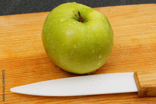 Wet green apple and knife