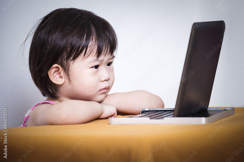 Adorable little asian (thai) girl watching a story on touchscree Adorable little asian (thai) girl watching a story on touchscree