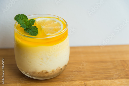 Lemon cheese cake on wooden plate with white background