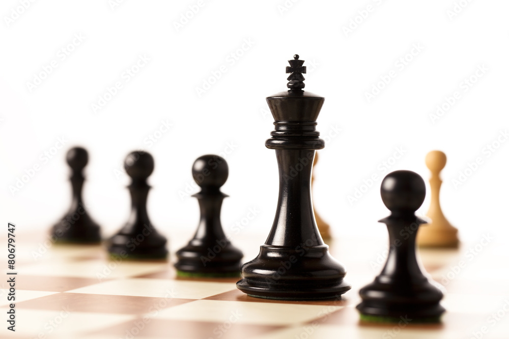 Black chess pieces on a chessboard standing in perspective Black chess pieces on a chessboard standing in perspective