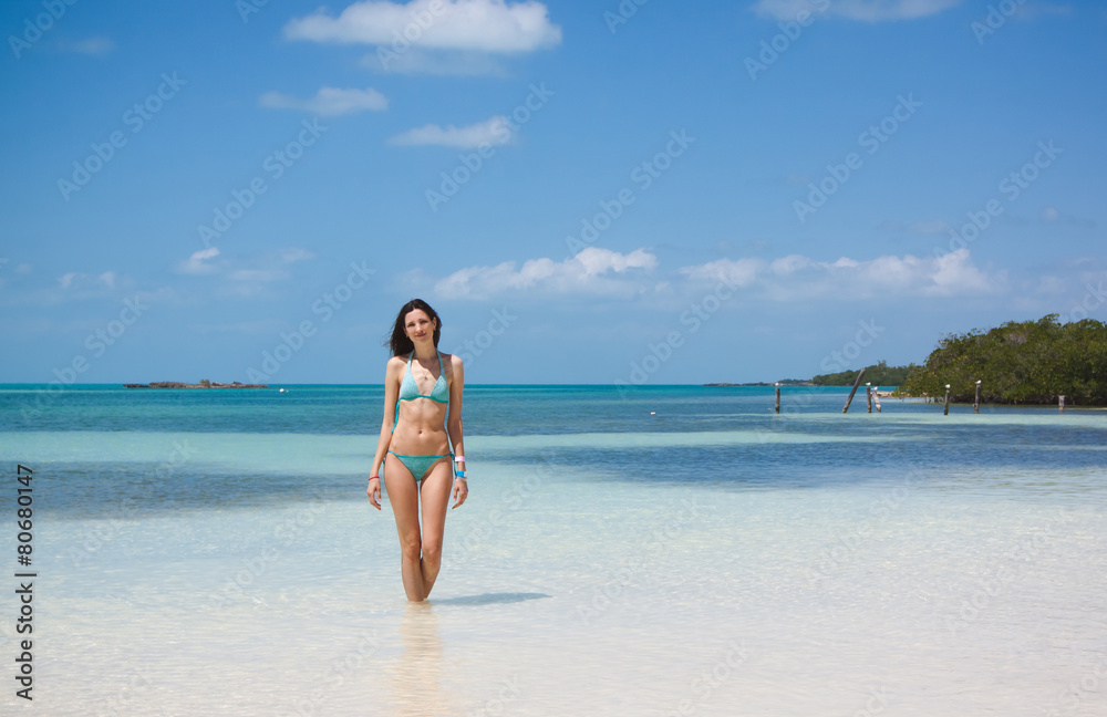 Young beautiful woman staying in the tropical blue sea on the wh