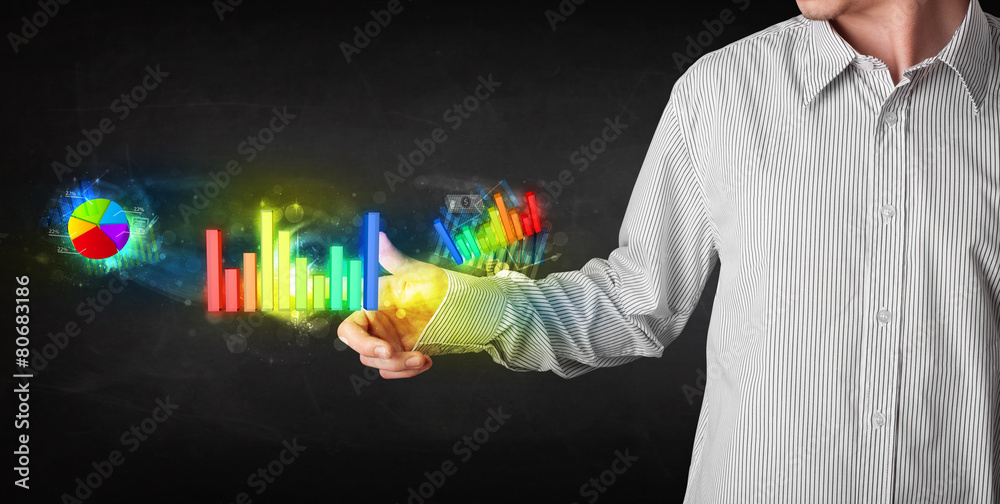Handsome young business man touching colorful modern graph syste Handsome young business man touching colorful modern graph syste