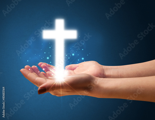 Glowing cross in the hand of a woman