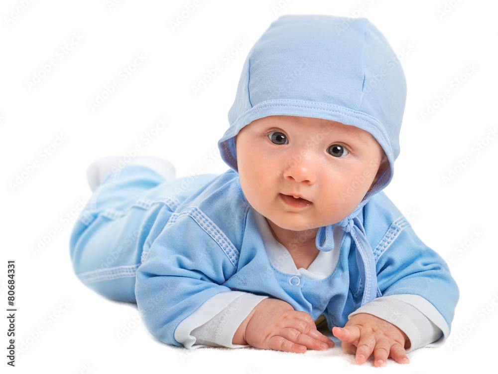 Cute baby boy on his tummy on a white blanket, in blue clothes w Cute baby boy on his tummy on a white blanket, in blue clothes w