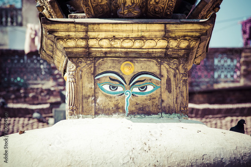 Buddha eyes close up with prayer flags at Bodhnath stupa in Kath photo