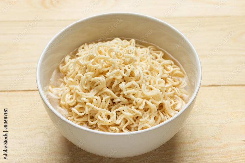 Instant noodles in white dish on wood background Instant noodles in white dish on wood background