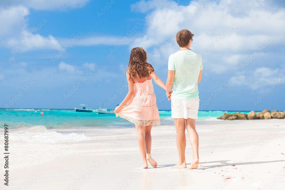 back view of happy young couple on the beach