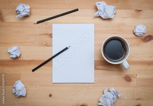 Blank notepad with pencil and coffee on wooden desk