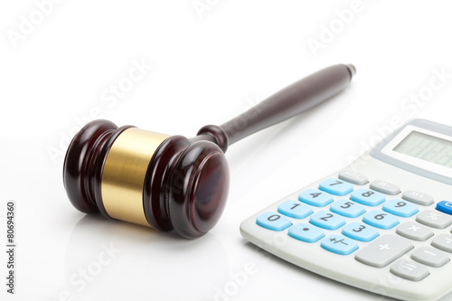 Wooden judge's gavel and calculator next to it