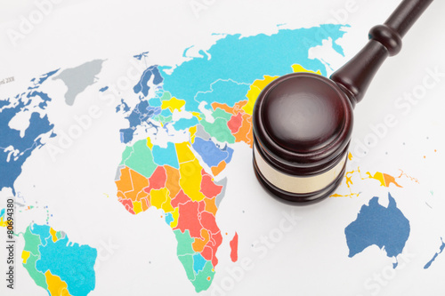 Wooden judge's gavel and over world map photo