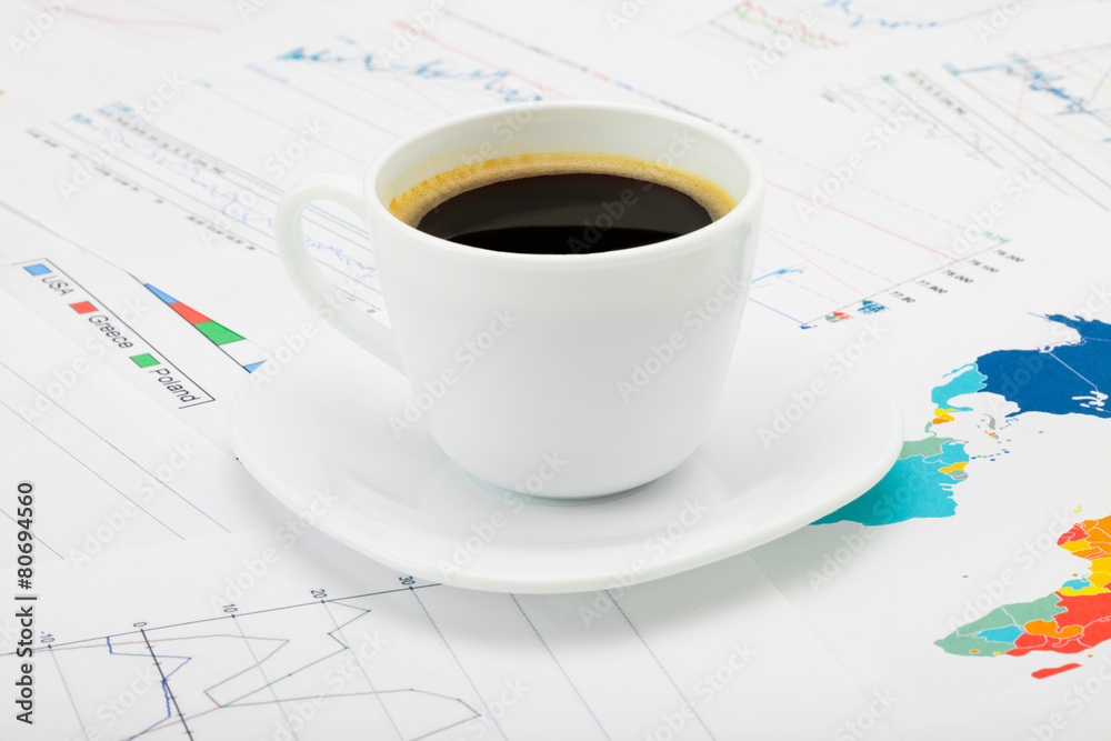 Coffee cup over some financial charts Coffee cup over some financial charts