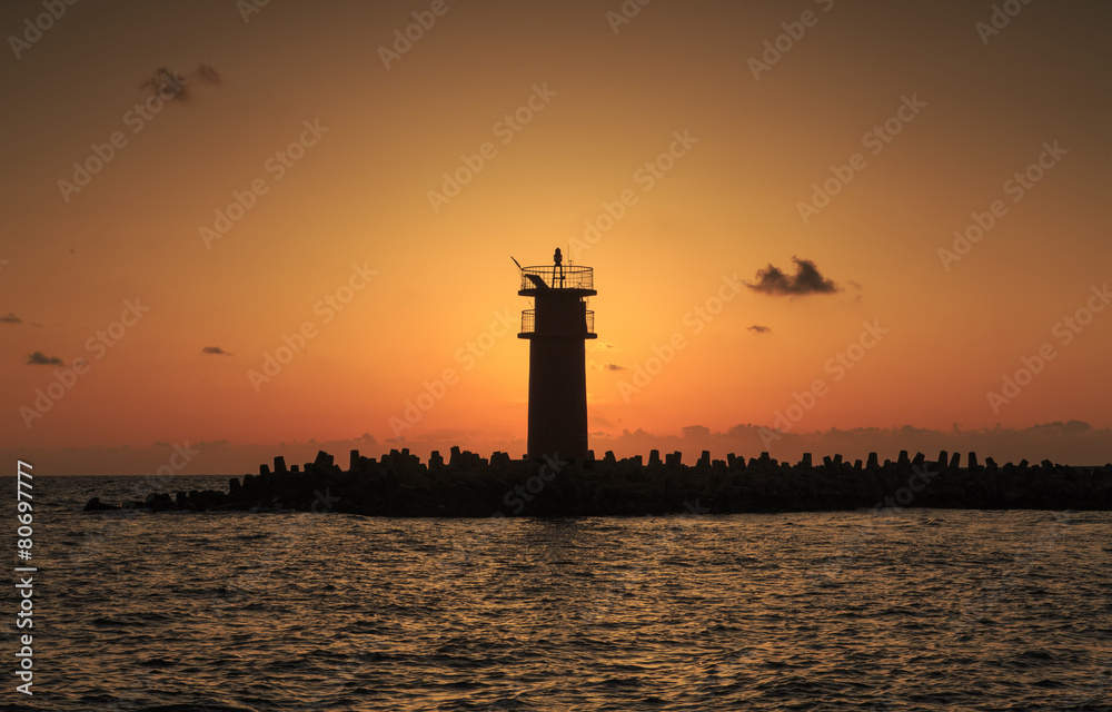 Beautiful Vibrant Sunrise Sky Over Calm Sea Water And Lighthouse