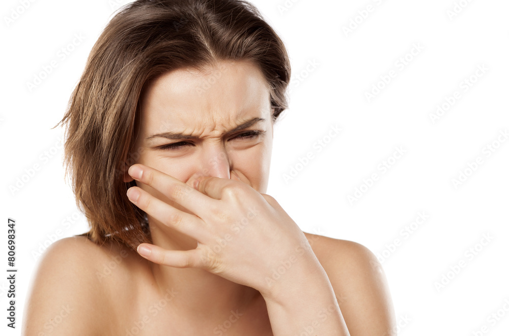 young pretty girl closes her nose because of the smell young pretty girl closes her nose because of the smell