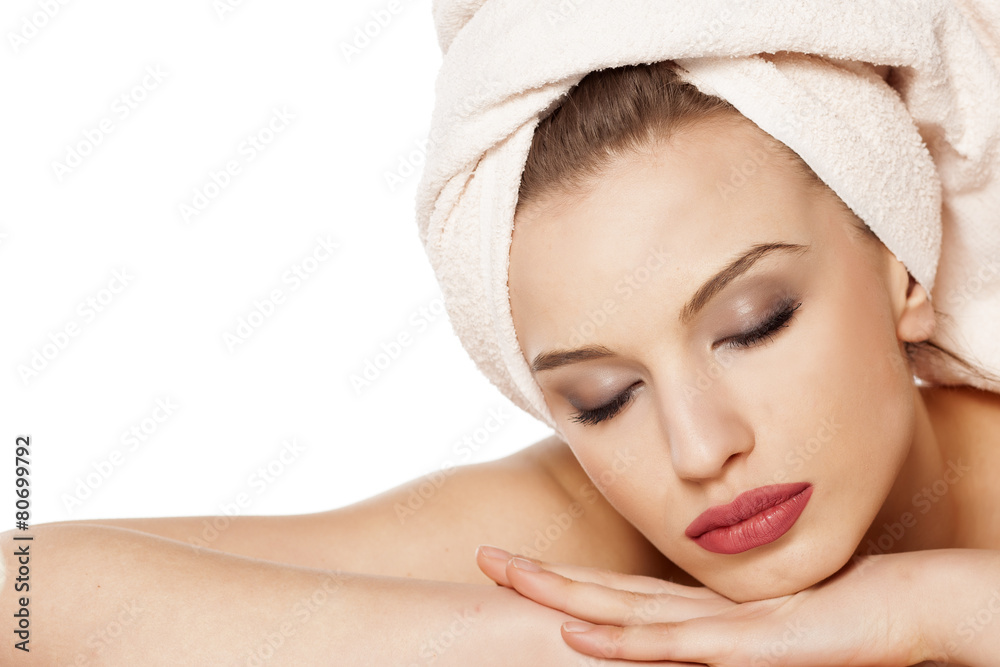 beautiful woman with a towel on her head lying on white