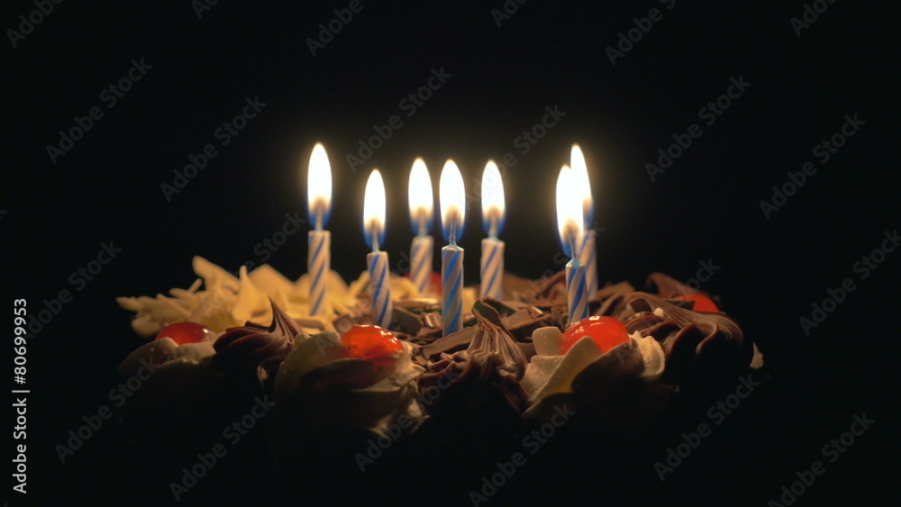 Blowing out birthday candles on delicious chocolate cake