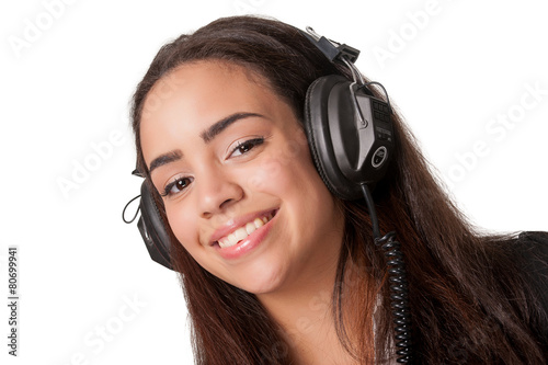 Young brunette lady listening to headphones, on white
