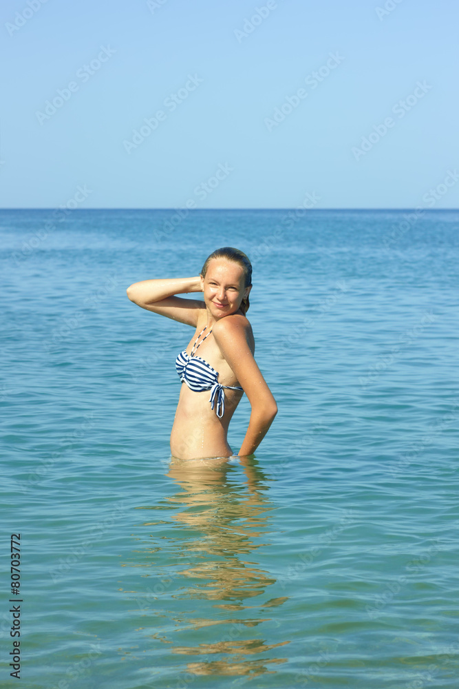 Teenage girl standing waist-deep in seawater Teenage girl standing waist-deep in seawater