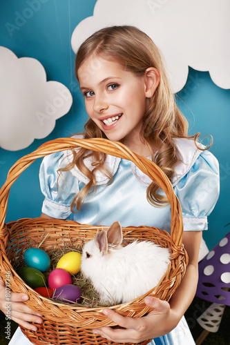 Little girl with basket with color eggs and white Easter bunny
