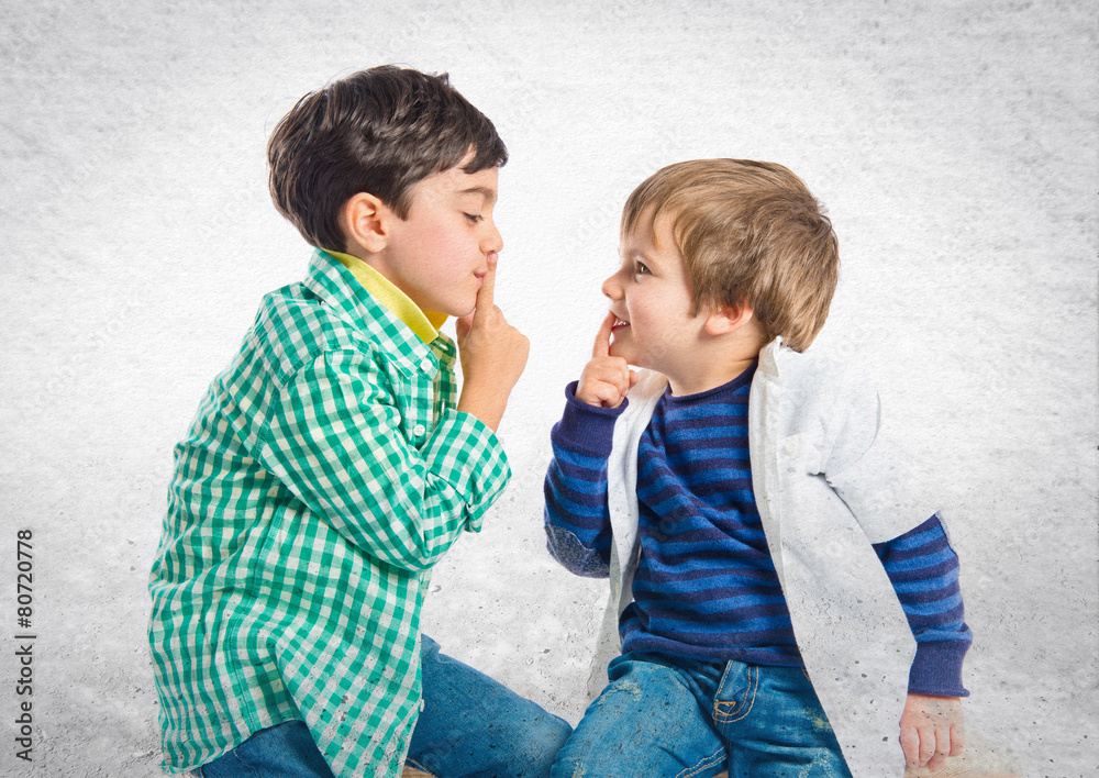 Kids doing silence gesture over white background Kids doing silence gesture over white background