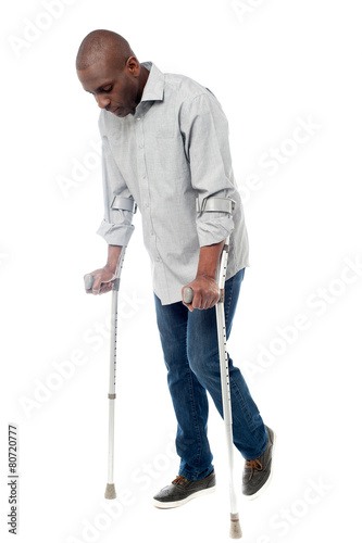 Young man with crutches trying to walk Fototapet
