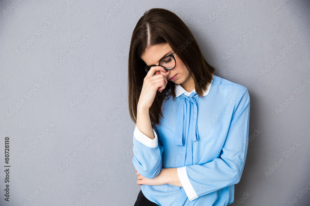 Pensive businesswoman over gray background Pensive businesswoman over gray background