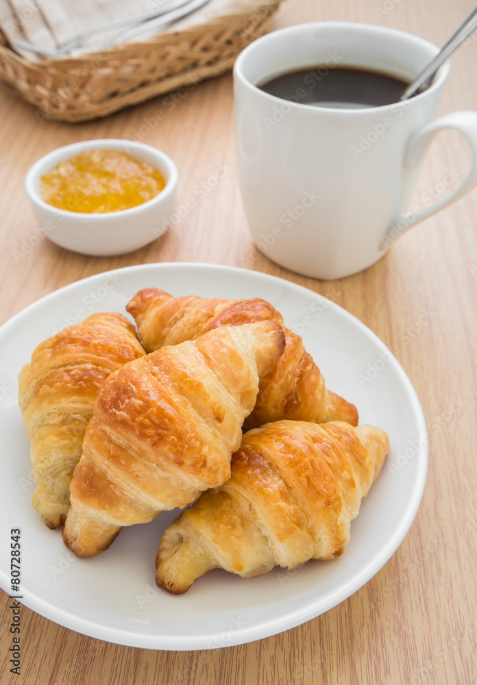 Croissants with jam and coffee cup Croissants with jam and coffee cup