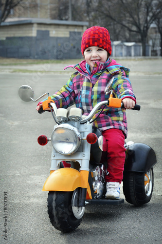 In the spring a little girl riding a motorcycle.