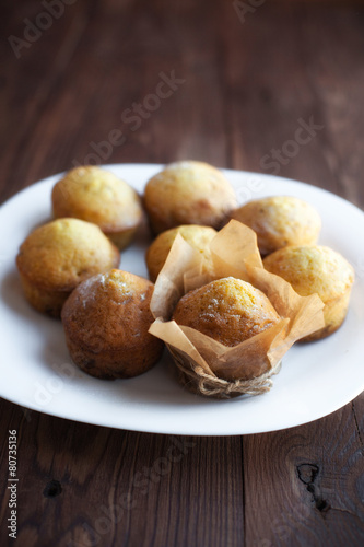 Homemade muffins in plate on wood table