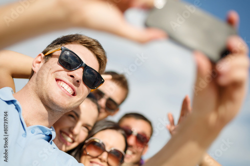 group of friends taking selfie with cell phone