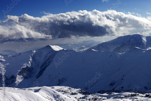 Winter mountains at evening and sunlight clouds