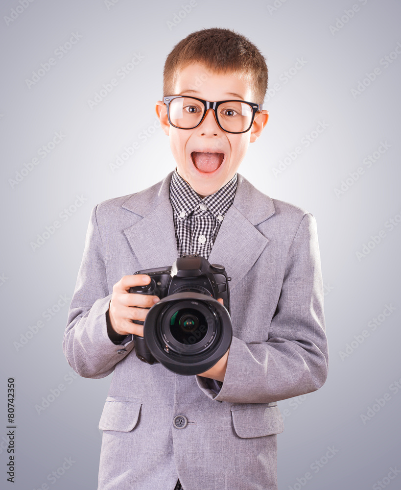 Fototapeta premium kid holding a dslr camera on a blue background