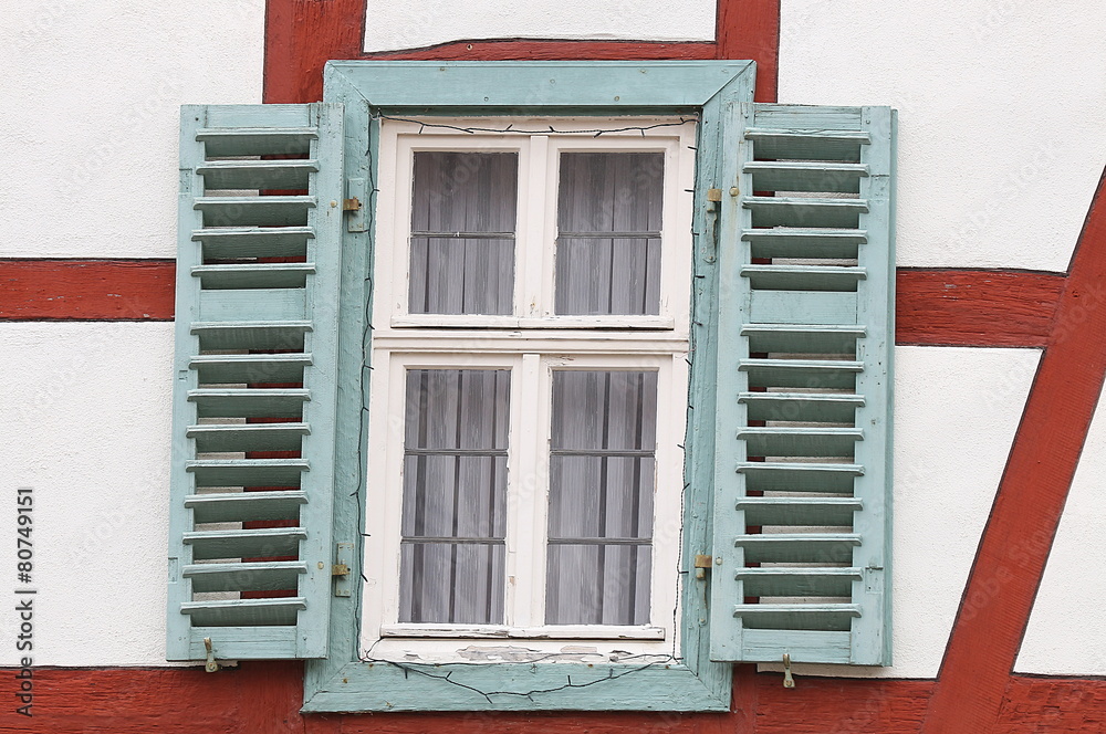 Fototapeta premium Altes Haus mit rotem Fachwek und grünem Fenster