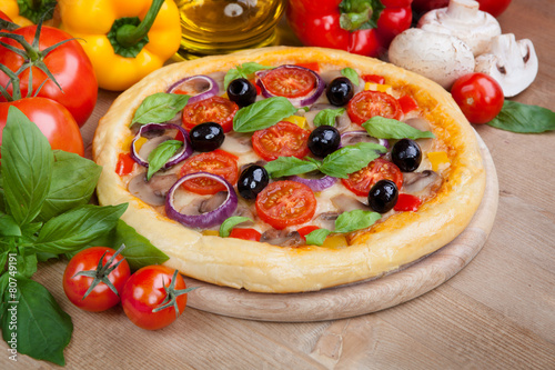 Tasty pizza and fresh ingredients on the table