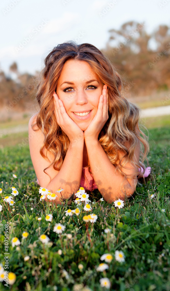 Cool woman lying on the grass surrounded by flowers Cool woman lying on the grass surrounded by flowers