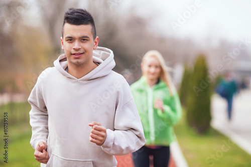 Handsome young man jogging on running track