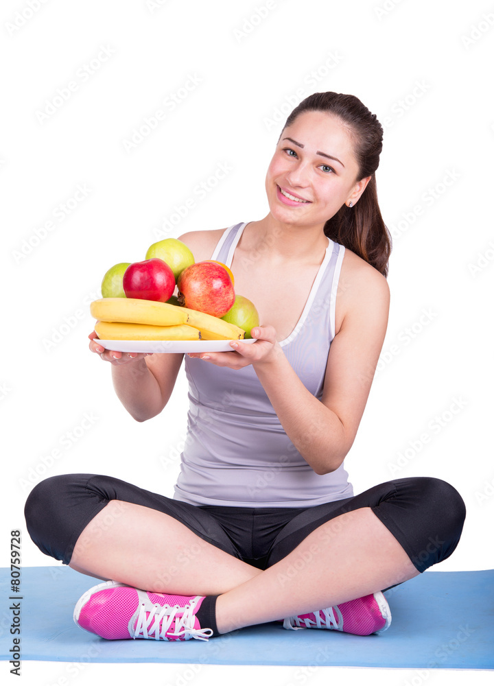 girl sitting on sport mat holding fruits in hands girl sitting on sport mat holding fruits in hands