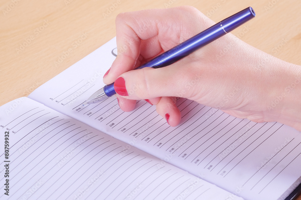 Female hand with pen and notebook Female hand with pen and notebook