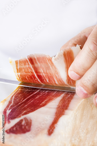 Profesional cortando lonchas de jamón serrano a cuchillo