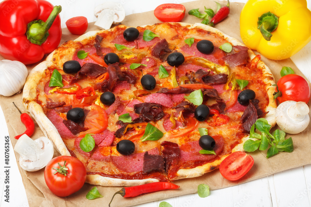 Hot pizza with ingredients on wooden table still life Hot pizza with ingredients on wooden table still life