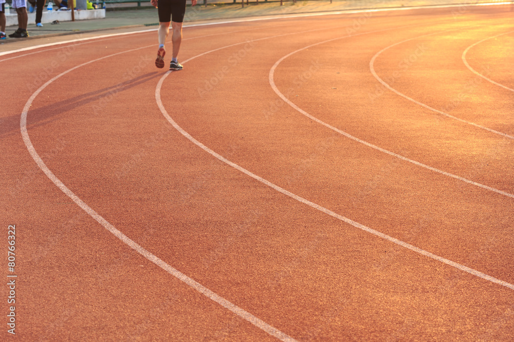 Running track with blur of runner feet in stadium