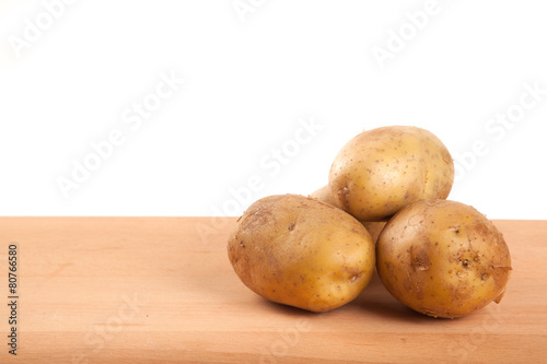 Four  potatoes on wooden table