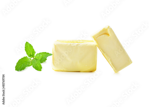 Stick of butter and mint leaves isolated on white.