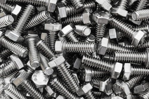 Metal screw and nuts on texture background.