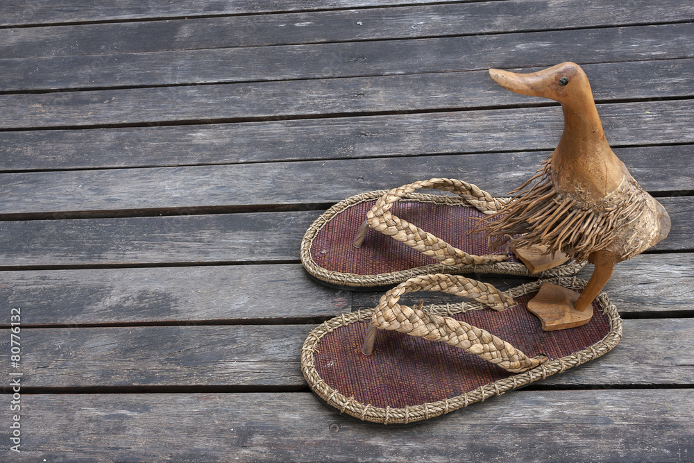 Fototapeta premium Wooden duck on sandals