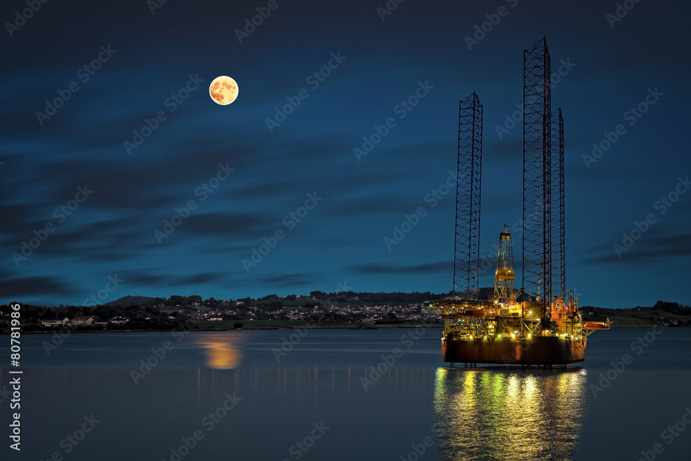 Oil platform at night time and the moon.