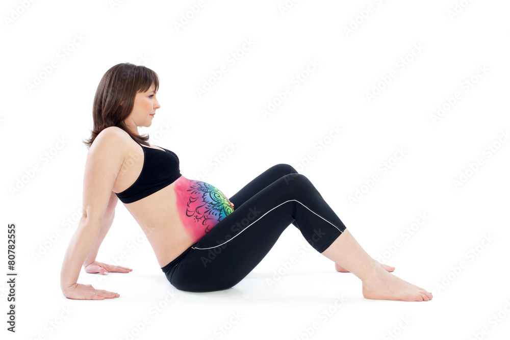 Woman with painted belly doing yoga exercise Woman with painted belly doing yoga exercise